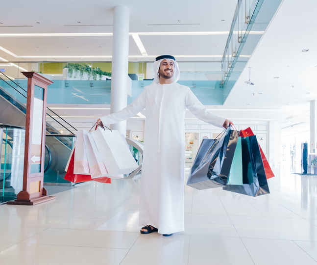 Young Arab man carrying shopping bags in a modern shopping mall